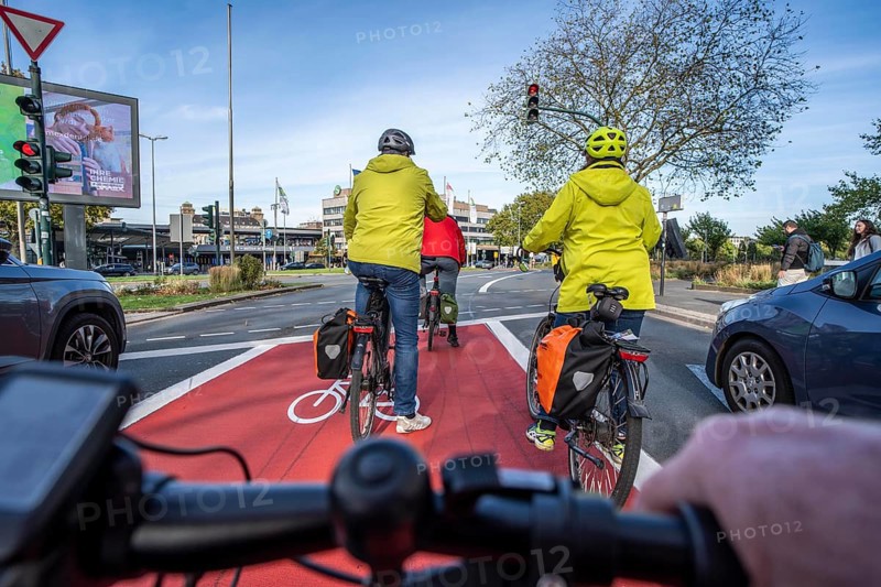 Riding a bike in a bike lane, marked in red to attract the attention of motorists, between 2 lanes, Huyssenallee, in front of Europaplatz, in the city centre of Essen, North Rhine-Westphalia, Germany
