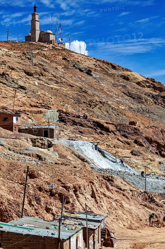 Church on a mountain in a barren, dry landscape with antennas and stone houses under a blue sky, The silver mines of Potosi Bolivia