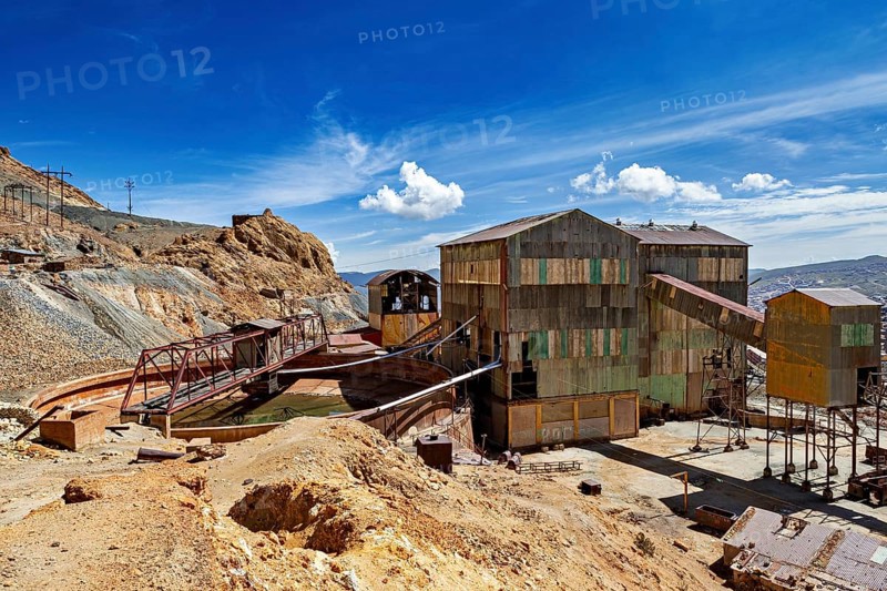 Abandoned industrial plant with rusty buildings against a blue sky and clouds, The silver mines of Potosi Bolivia