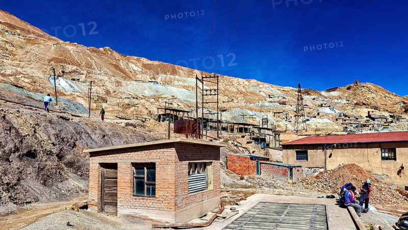 Small buildings in a dry, desert-like mining area with people, The silver mines of Potosi Bolivia