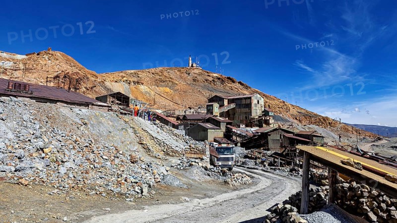Old industrial complex in a mountainous environment under a clear blue sky with a visible path, The silver mines of Potosi Bolivia