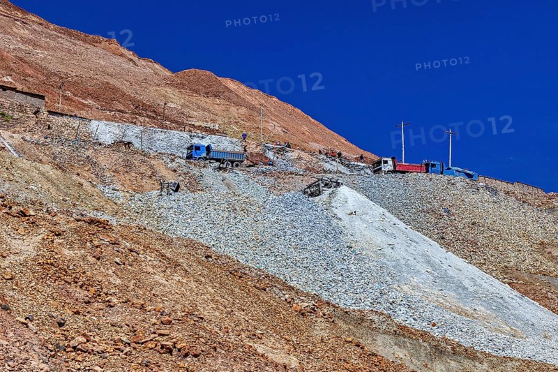 Lorries parked on the slope of a rocky mountain under a clear blue sky, The silver mines of the Cerro Rico silver mountain near Potosi in Bolivia