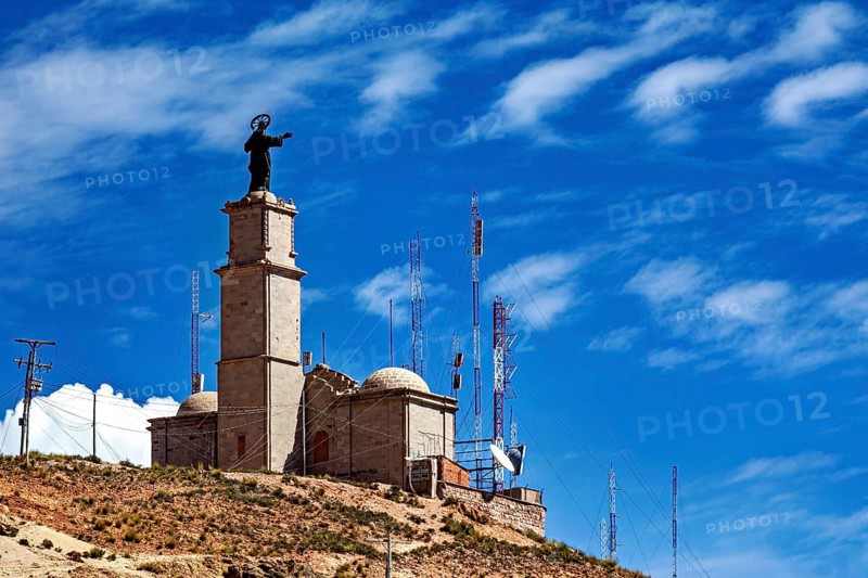 Tower with statue and antennae on a hill under a clear blue sky, The church on the Cerro Rico silver mountain near Potosi Bolivia