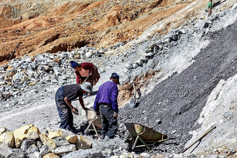 Labourers work together while moving gravel on a rough hillside, The silver mines of Potosi Bolivia