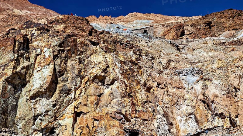 Textured rock face on a mountainside under a clear blue sky, The silver mines of Potosi Bolivia
