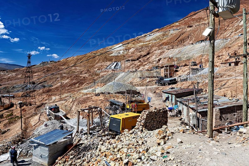 Huts and cable poles on the mountainside with an intense blue sky in the background, The silver mines of Potosi Bolivia