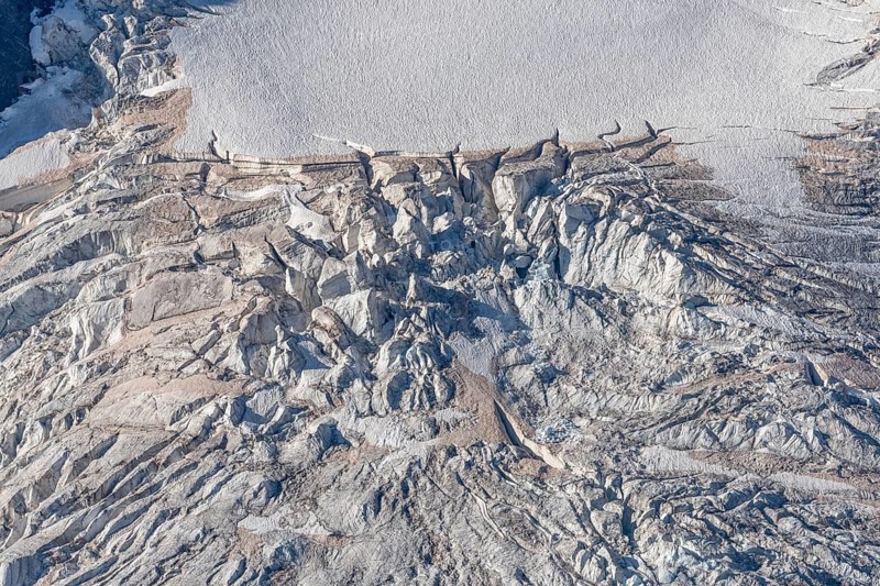Intricate patterns of ice and rock are showcased in this stunning glacial landscape, revealing the effects of time on the frozen surface. The bright daylight emphasises the textures and colours. Gorner Glacier, Zermatt, Valais, Alps, Swiss