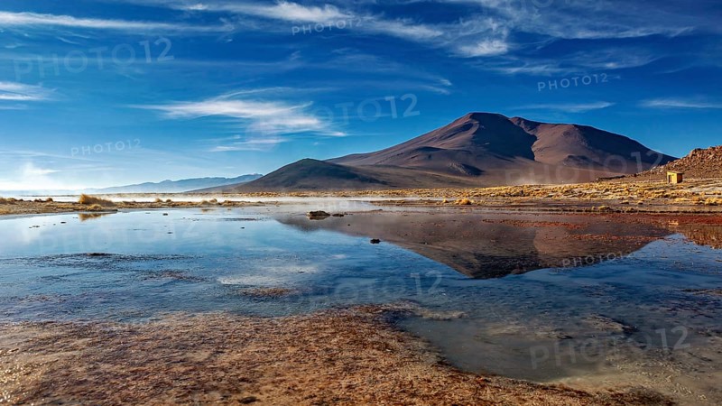 Peaceful mountain landscape with a clear lake and clouds in the sky creating a tranquil atmosphere, The thermal springs of Polques in Bolivia