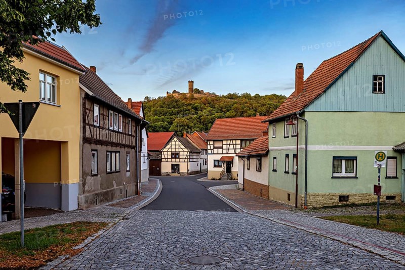Historic village with half-timbered houses, castle ruins on a green hill and cobbled street, the village of Mühlburg in Thuringia near Erfurt