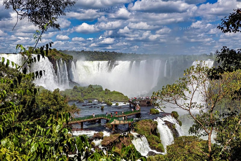 Green jungle and dramatic waterfalls, visitors on a wooden platform, The Iguazu Falls between Argentina and Brazil