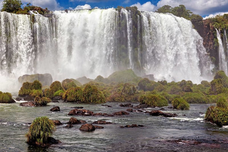 Close-up of a powerful waterfall with lush vegetation and spray, The Iguazu Falls between Argentina and Brazil