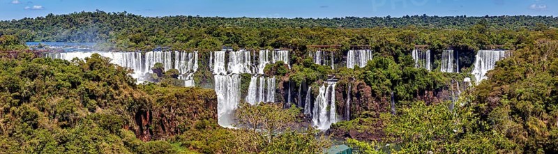 Sweeping view of the waterfalls with flowing river and green forest, The Iguazu Falls between Argentina and Brazil