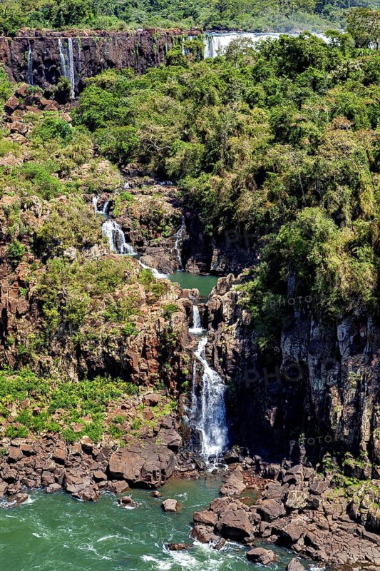 High waterfall with surrounding forest and rocks, harmonious natural scenery, The Iguazu Falls between Argentina and Brazil