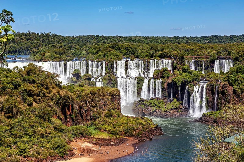 Impressive view of majestic waterfalls with a small sandy beach, The Iguazu Falls between Argentina and Brazil