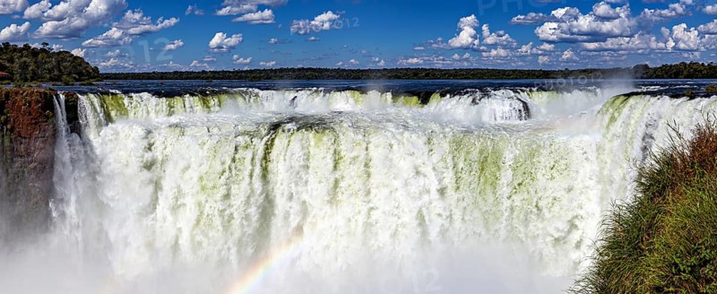 Impressive panoramic view of a chain of waterfalls under a cloudy sky, The Iguazu Falls between Argentina and Brazil