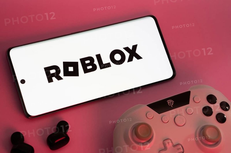Dhaka, Bangladesh- 26 July 2025: A close-up of a gamepad with the Roblox seen on smartphone