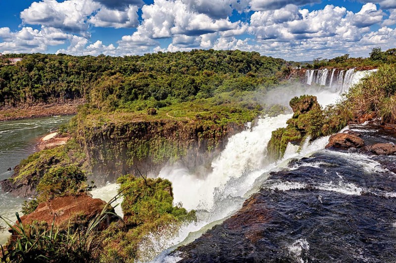 Impressive waterfall with foaming river and lush vegetation, The Iguazu Falls between Argentina and Brazil