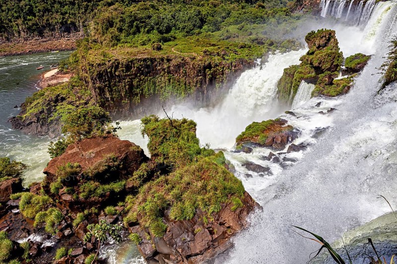 River landscape with waterfall, surrounded by dense vegetation and rocks, The Iguazu Falls between Argentina and Brazil