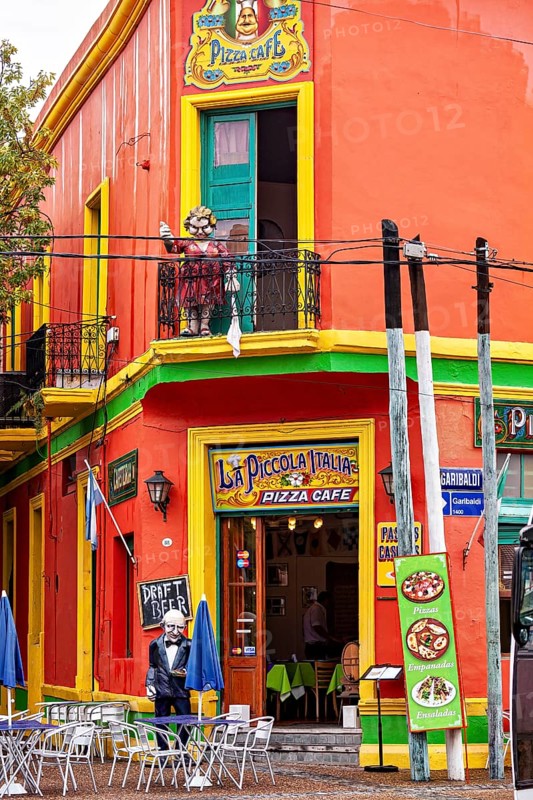 A lively pizza café with bright colours and balconies in a busy city street, the colourful city and tango district of La Bocca in Buenos Aires Argentina