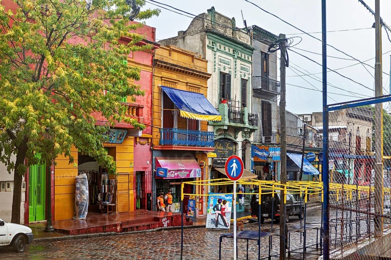 Lively street with colourful buildings and wet cobblestones on a cloudy day, The colourful city and tango district La Bocca in Buenos Aires Argentina