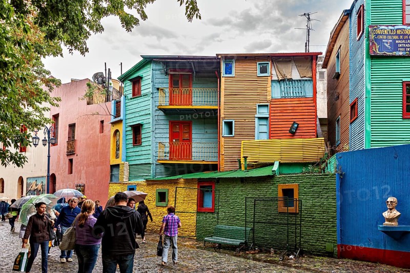 Colourful buildings with people on a cobbled street, lively and creative atmosphere, The colourful city and tango district La Bocca in Buenos Aires Argentina