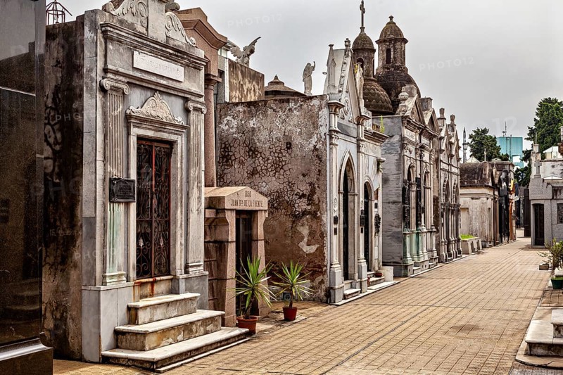 Cemetery avenue with historic and decorative mausoleums along a paved path, La Recoleta Cemetery in Buenos Aires Argentina