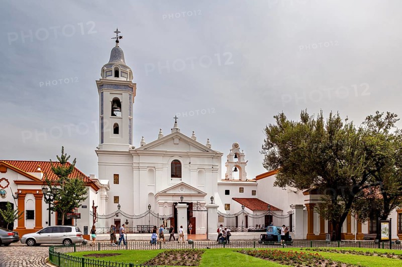 White church with bell tower and people in the forecourt in a quiet neighbourhood, La Recoleta cemetery in Buenos Aires Argentina