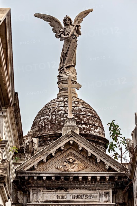 Angel sculpture on decorated dome above a historic building with Gothic design, La Recoleta cemetery in Buenos Aires Argentina