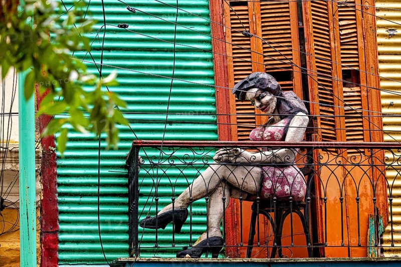 Sculpture of a woman on a decorative balcony with a coloured wall, The colourful city and tango district of La Bocca in Buenos Aires Argentina