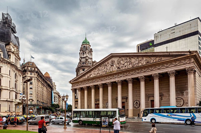 An impressive columned building against an overcast sky, surrounded by city buses, Historic buildings in the city of Buenos Aires Argentina