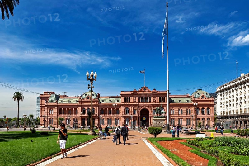 Historic building with surrounding gardens and flag, sunny day in Buenos Aires, The presidential palace Casa Rosada in Buenos Aires Argentina