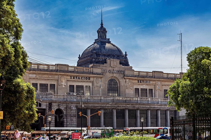 A large railway station with a dome, surrounded by trees and traffic under a blue sky, The city of Buenos Aires in Argentina