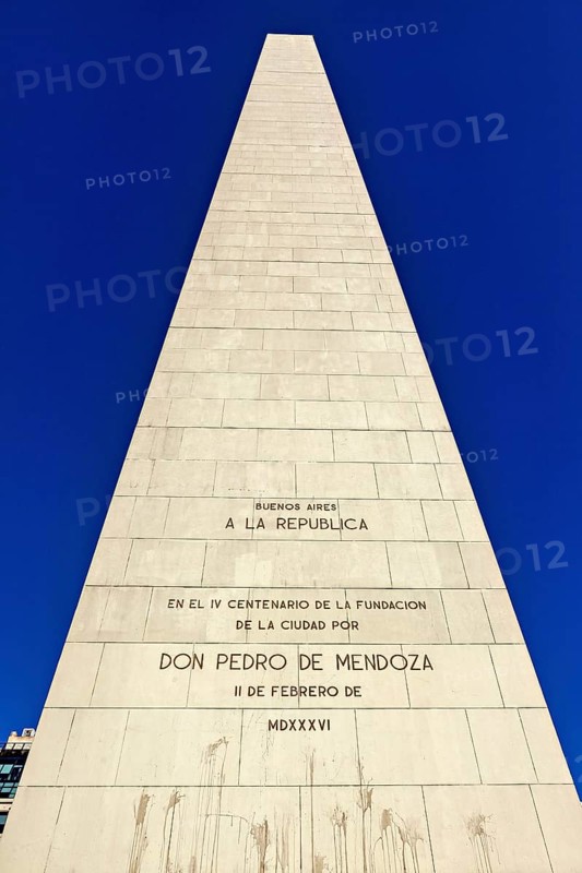 Close-up of an obelisk with engraved inscriptions against a clear blue sky, The great obelisk in the city of Buenos Aires Argentina