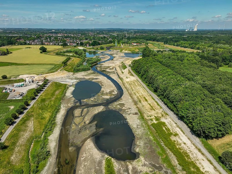 Dortmund, Castrop-Rauxel, North Rhine-Westphalia, Germany - River renaturalisation, renaturation of the Emscher, flood retention basin HRB Mengede. A new floodplain landscape is being created at the Emscher-Auen farm, expanding the area for flood protection during heavy rainfall and for biodiversity. The previously straightened Emscher is being given curves again and can meander through its new floodplain. Following the construction of a parallel sewer, the Emscher has been completely free of sewage since 2022. The river was previously an open, above-ground mixed water channel with rainwater and wastewater. At the back right, the Uniper coal-fired power plant Datteln 4 power station
