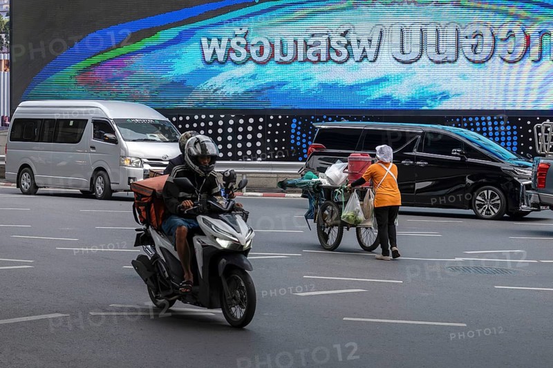 Street crossing woman with cookshop, Bangkok, Thailand