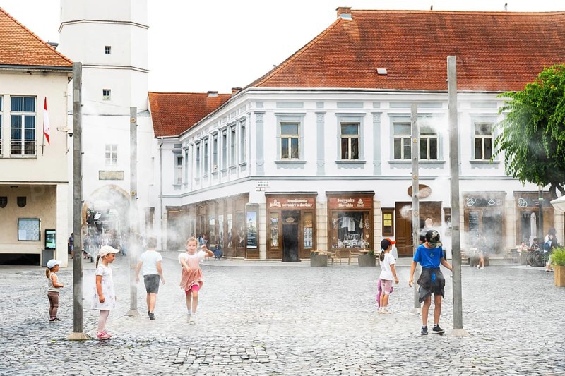Water mist system in the city centre of Trencin, children use the refreshment in the summer heat, Trencín, Slovakia