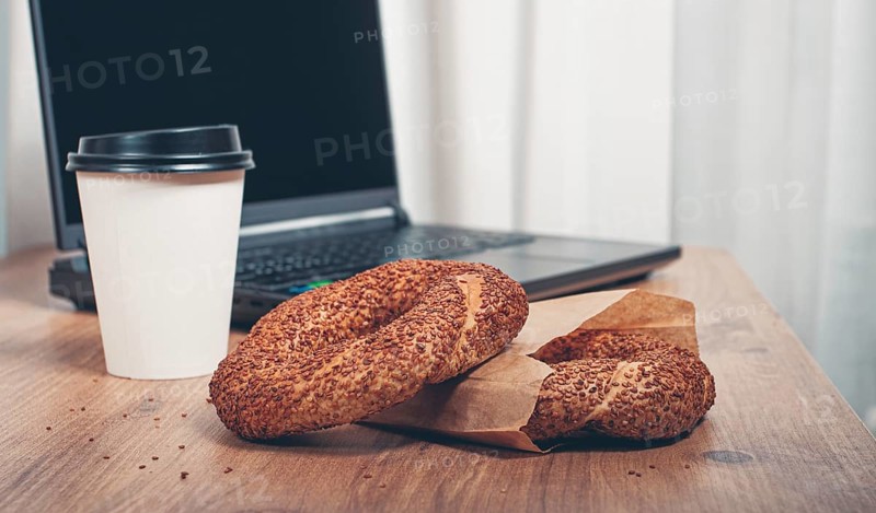 Simits with coffee on a wooden table, with a laptop, in a cozy working environment, snack, breakfast, no people