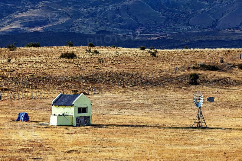 Abandoned small building with windmill in a dry, expansive landscape, The Patagonian landscape near El Chalten in Argentina