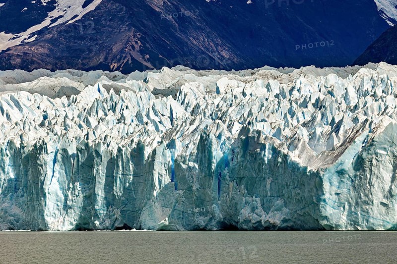 Detailed view of a massive blue glacier against a mountain backdrop, The Perito Moreno glacier in Argentina