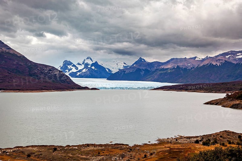 Tranquil landscape with a large lake and glaciers, surrounded by cloudy mountains, The Perito Moreno glacier in Argentina