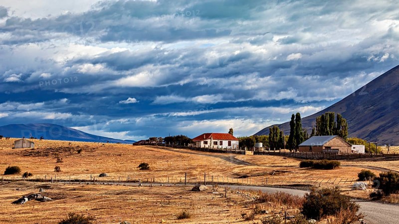 Lonely house in a rural setting with fields and mountains under a dramatic sky, The Patagonian landscape near El Chalten in Argentina
