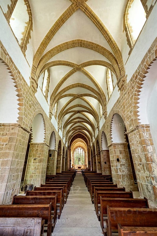 Interior view of a Gothic church with impressive arches and wooden rows of seats, The Abbey de La Lucerne in Normandy, France