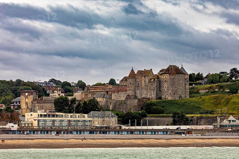 Medieval castle with surrounding town on the beach, under a cloudy sky, historical ambience, Dieppe Castle in Normandy, France