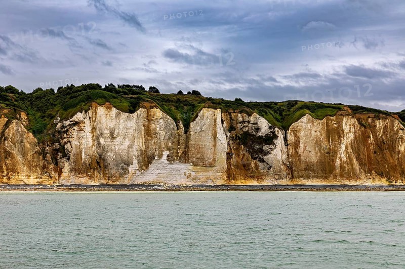Imposing rocks on the coast with calm sea and cloudy sky, The coast of Dieppe in Normandy, France