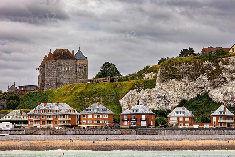 Castle on cliffs above modern buildings, cloudy sky, historic architecture by the sea, Dieppe Castle in Normandy, France