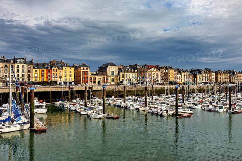 Historic buildings line a harbour full of boats under a cloudy sky, The harbour of Dieppe in Normandy, France