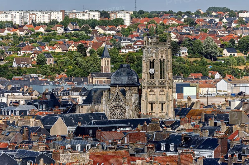 Town view with striking church tower surrounded by old tiled roof houses and green surroundings, The town of Dieppe in Normandy, France
