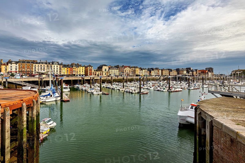 View of a harbour with many boats and historic buildings under a dramatic sky, The harbour of Dieppe in Normandy, France