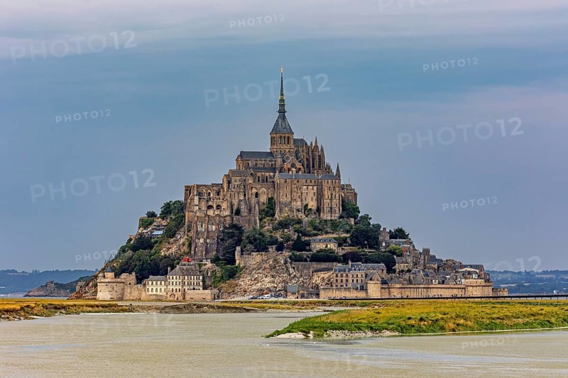 A castle on an island in a river, against a greying sky, Mont Saint Michel in Normandy, France