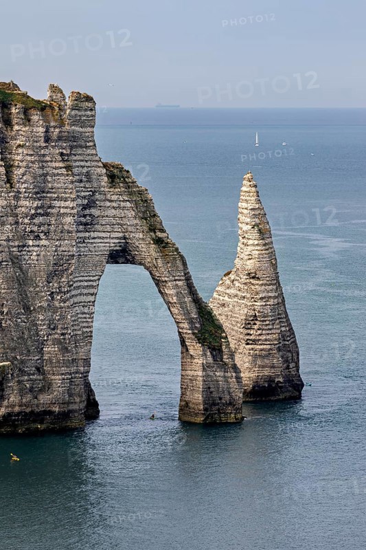 Iconic rock formation with natural arch over the blue sea, The cliffs and alabaster coast of Etretat in Normandy France